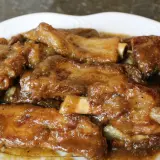 Costillas guisadas de la abuela, tiernas y jugosas, bañadas en una salsa casera que evoca recuerdos.