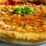 Pizza casera con masa perfecta hecha en Thermomix, cubierta de tomate, queso fundido y albahaca fresca.