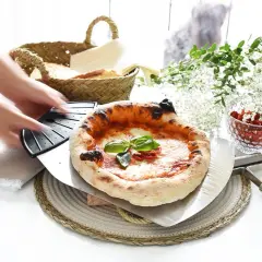 Manos estirando masa de pizza. Pizza recién horneada con albahaca y tomates secos, lista para servir.