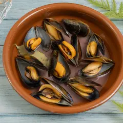 Mejillones frescos en una cazuela de barro, listos para preparar una deliciosa receta.