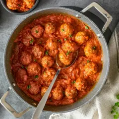 Sabrosas albóndigas caseras en una rica salsa de tomate, servidas en una sartén y cuencos.