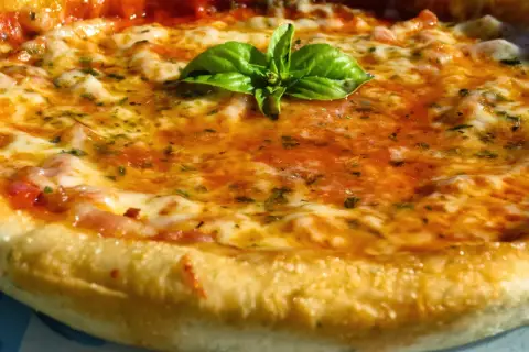 Pizza casera con masa perfecta hecha en Thermomix, cubierta de tomate, queso fundido y albahaca fresca.