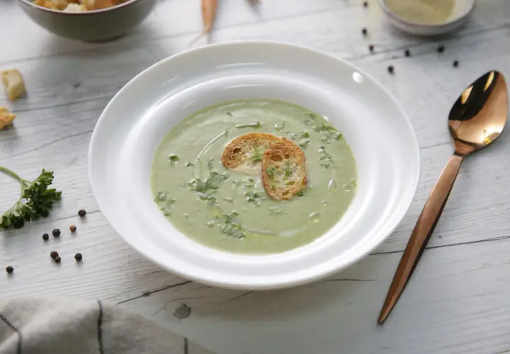 Un cremoso pure de verduras, decorado con tostadas crujientes y perejil fresco. Un plato ligero y saludable.