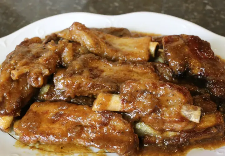 Costillas guisadas de la abuela, tiernas y jugosas, bañadas en una salsa casera que evoca recuerdos.