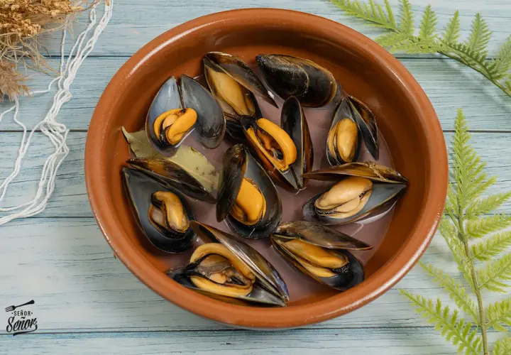 Mejillones frescos en una cazuela de barro, listos para preparar una deliciosa receta.