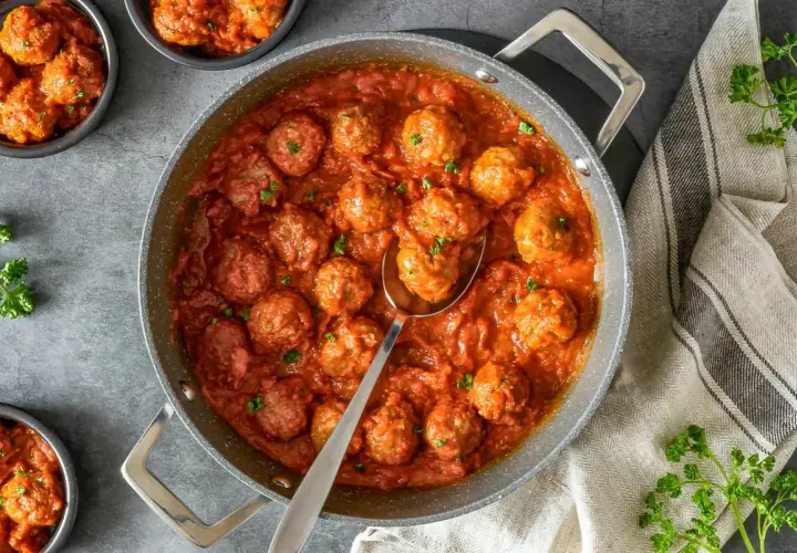 Sabrosas albóndigas caseras en una rica salsa de tomate, servidas en una sartén y cuencos.