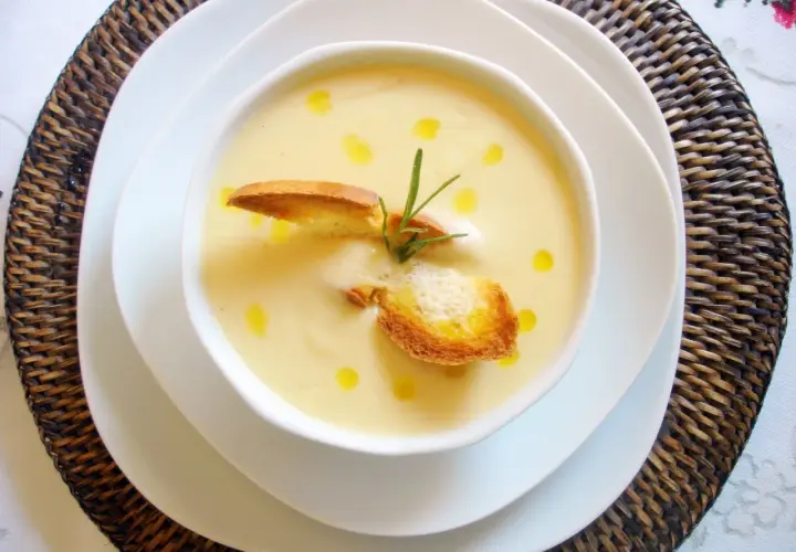 Crema de puerros y patatas con nata, coronada con picatostes crujientes y un toque de romero.