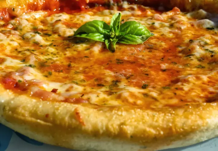 Pizza casera con masa perfecta hecha en Thermomix, cubierta de tomate, queso fundido y albahaca fresca.