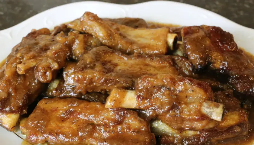 Costillas guisadas de la abuela, tiernas y jugosas, bañadas en una salsa casera que evoca recuerdos.
