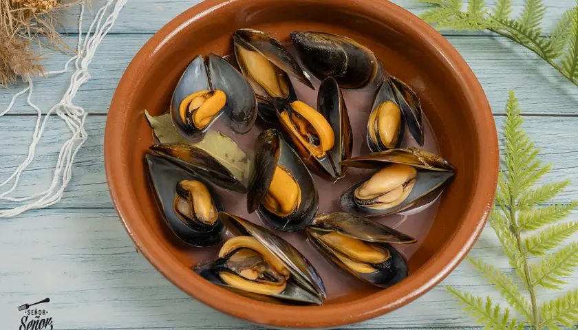 Mejillones frescos en una cazuela de barro, listos para preparar una deliciosa receta.
