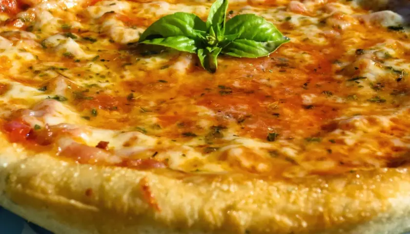 Pizza casera con masa perfecta hecha en Thermomix, cubierta de tomate, queso fundido y albahaca fresca.