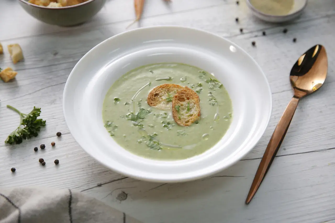 Un cremoso pure de verduras, decorado con tostadas crujientes y perejil fresco. Un plato ligero y saludable.