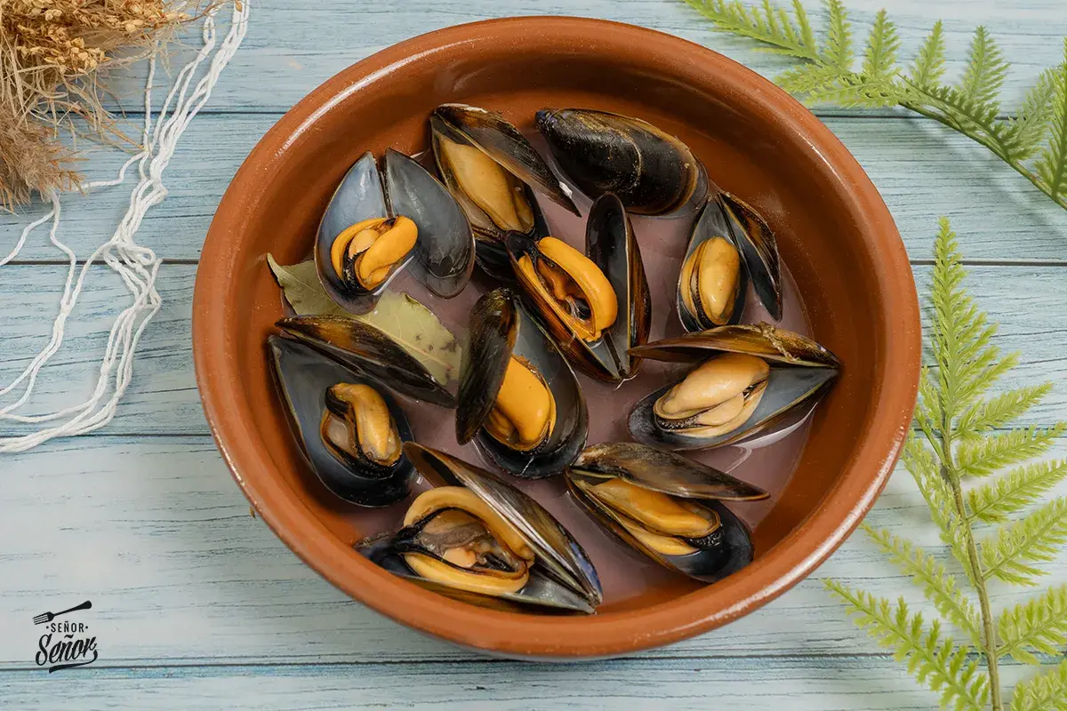 Mejillones frescos en una cazuela de barro, listos para preparar una deliciosa receta.