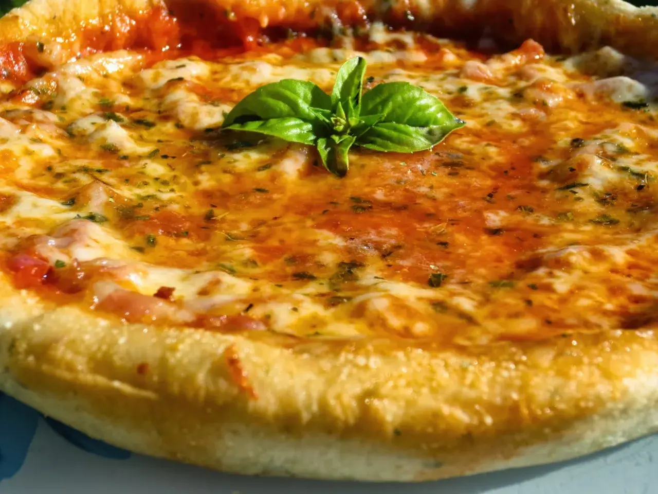 Pizza casera con masa perfecta hecha en Thermomix, cubierta de tomate, queso fundido y albahaca fresca.
