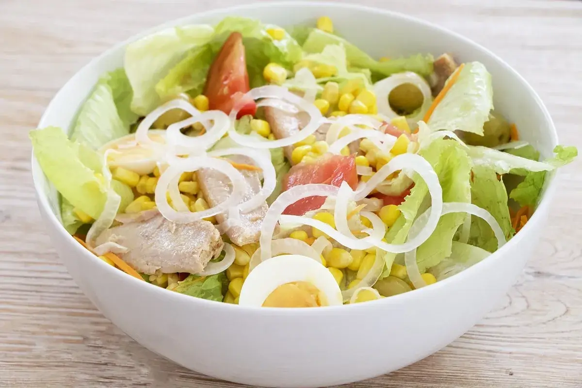 Deliciosa ensalada mixta con atún, huevo duro, maíz, tomate y cebolla. Fresca y completa.