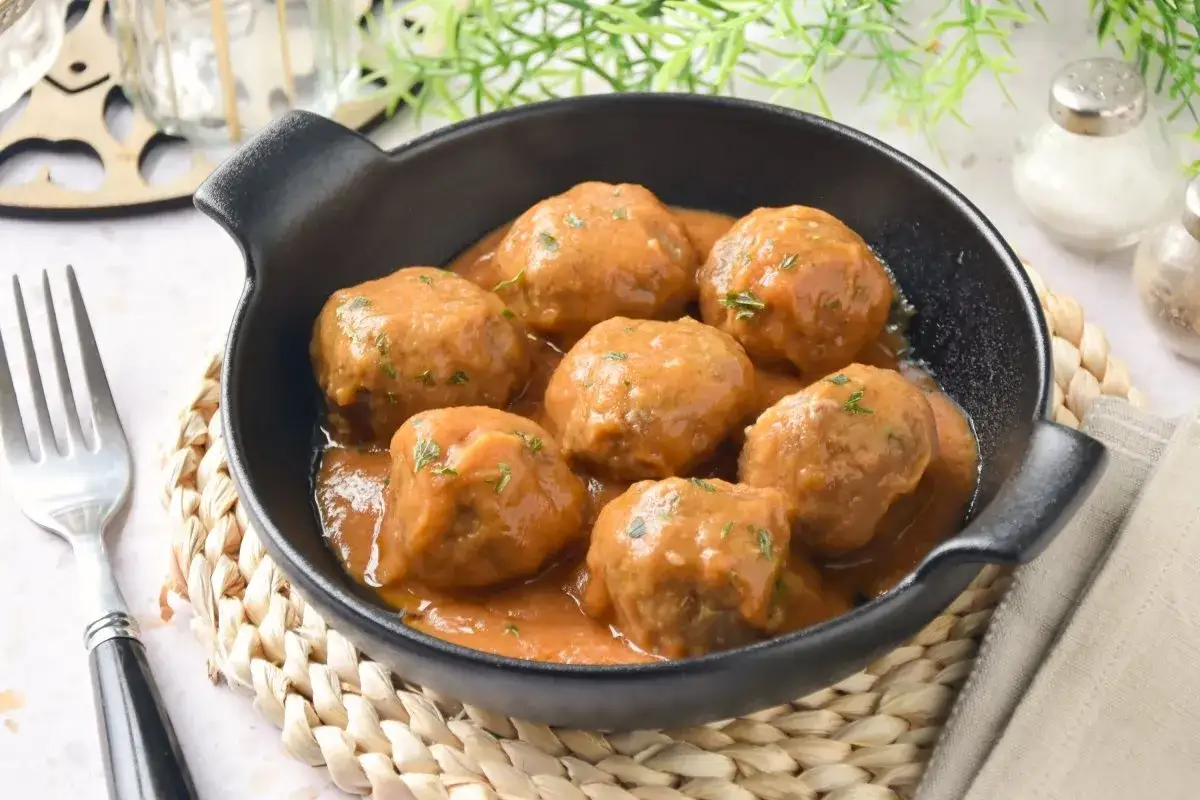 Sabrosas albóndigas caseras en una salsa cremosa, servidas en un cuenco negro.