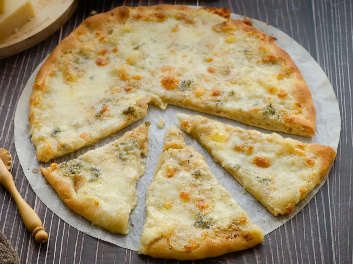 Pizza 4 formaggi con crosta dorada y queso derretido, lista para disfrutar.