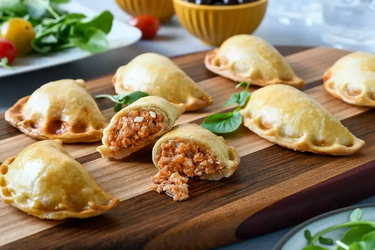 Deliciosas empanadillas al horno, doradas y rellenas de un sabroso guiso. Perfectas para cualquier ocasión.