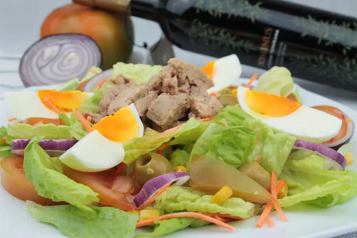 Ensalada mixta con atún, huevo duro, lechuga, tomate, cebolla morada y aceitunas. Perfecta para una comida ligera.