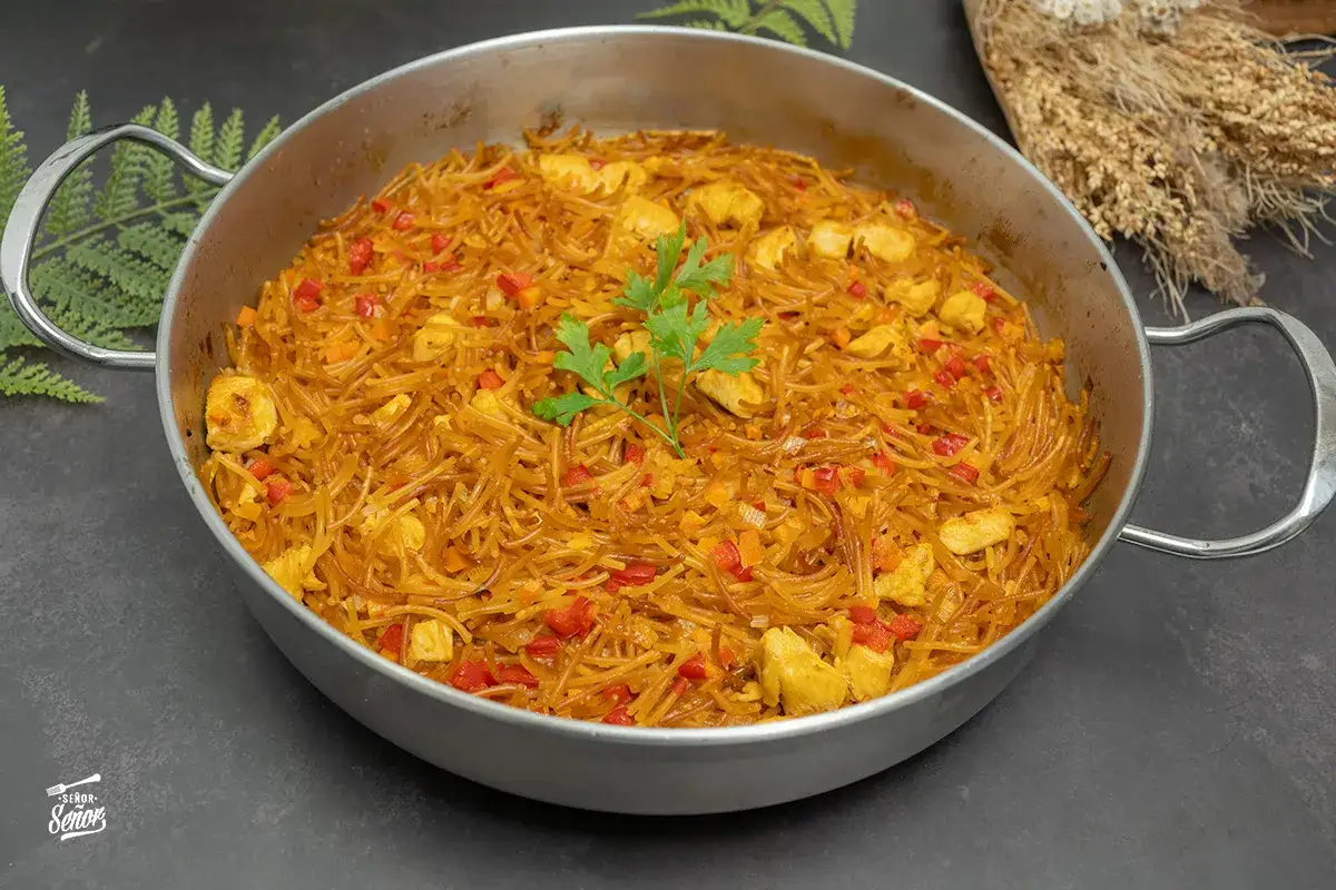 Fideu&agrave; de pollo en paellera, con fideos finos, trozos de pollo, pimiento rojo y perejil.