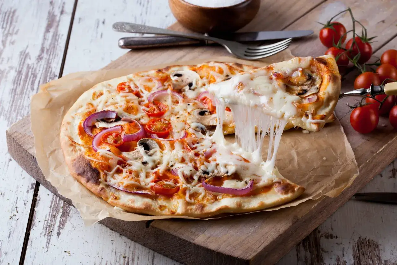 Pizza con queso derretido, tomates y cebolla. &iexcl;Qu&eacute; delicia!