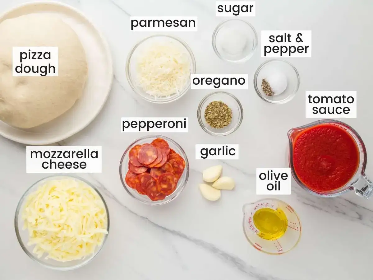 Ingredientes para pizza: masa, mozzarella, pepperoni, tomate, ajo, orégano, parmesano, aceite, sal, pimienta y azúcar.